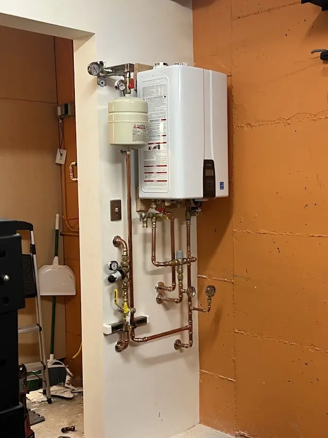 Plumbing technician inspecting water heater connections in Appleton